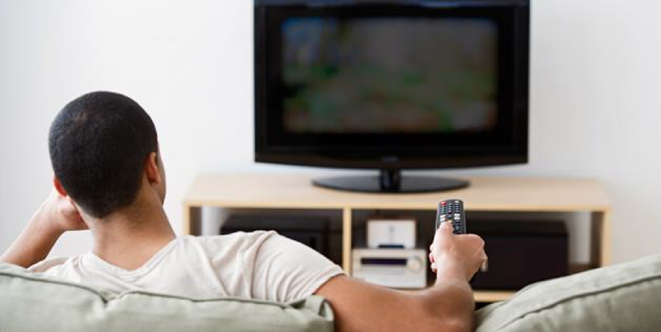 Телевизор читает видео. Парень у телевизора. Мужчина смотрит телевизор. Парень смотрит ТВ.
